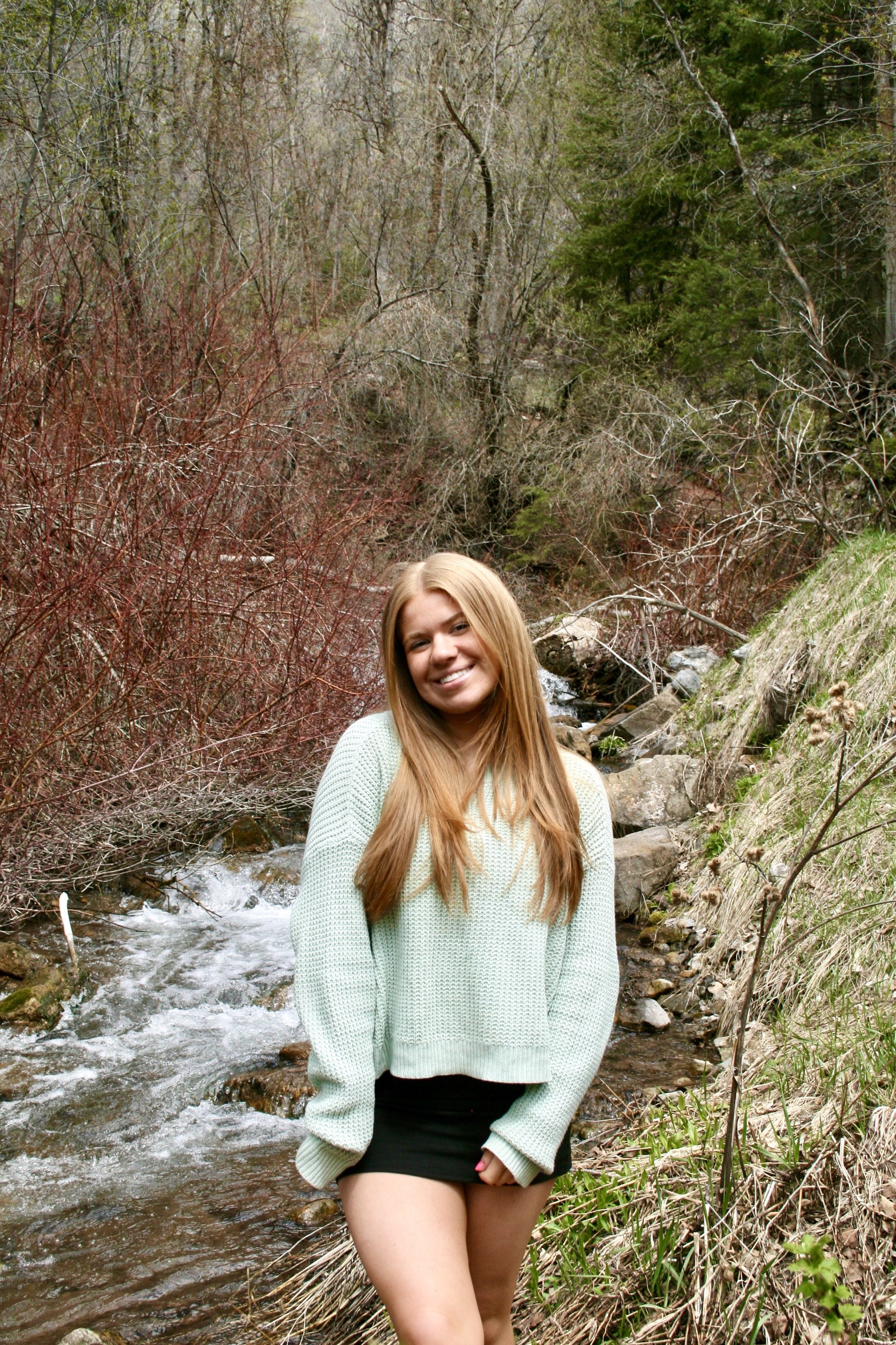 Senior portrait by forest stream